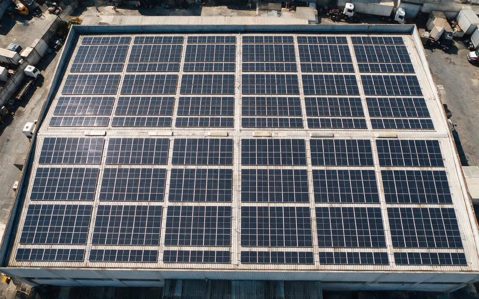 Vista aérea de galpão industrial com usina solar no telhado